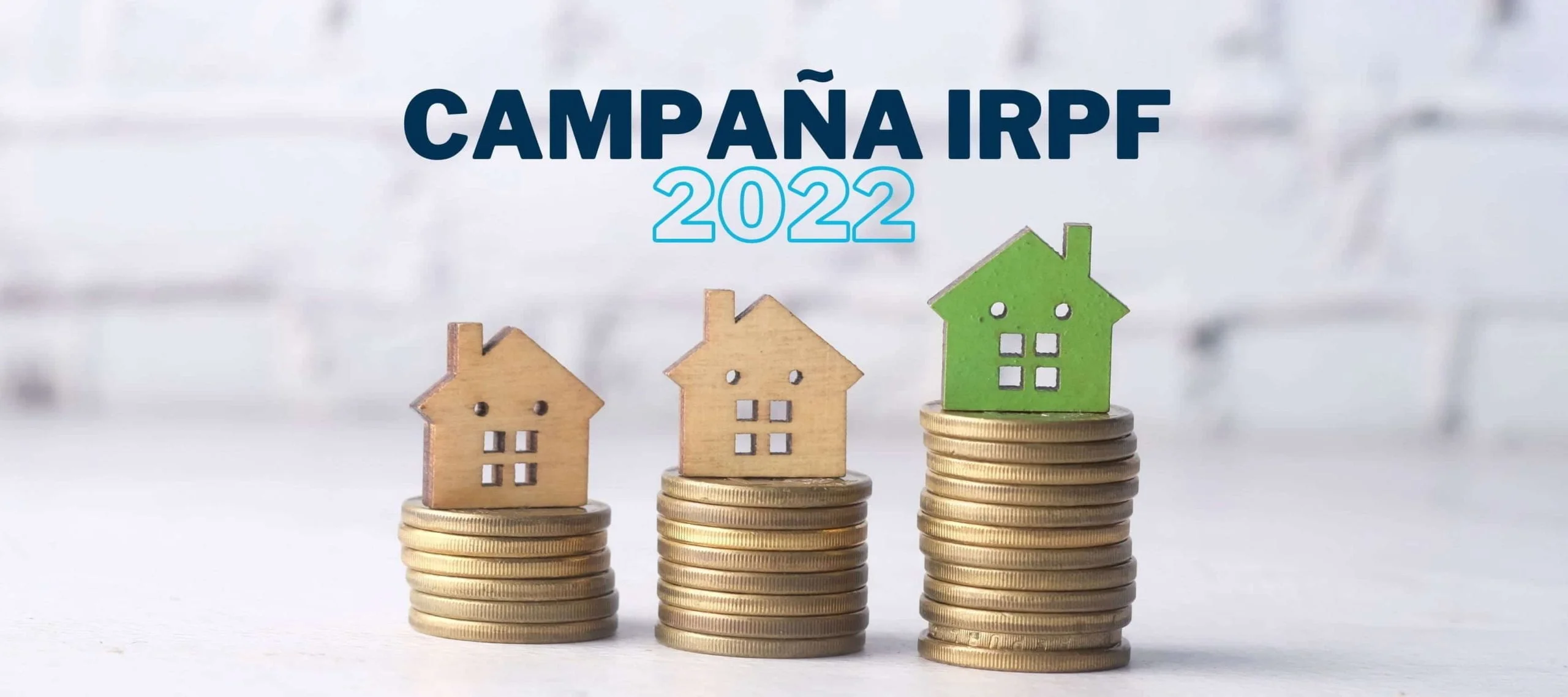 Imagen de casas de madera sobre monedas para hablar acerca de la campaña de la declaración de la renta 2022 en Iniciativa Fiscal.
