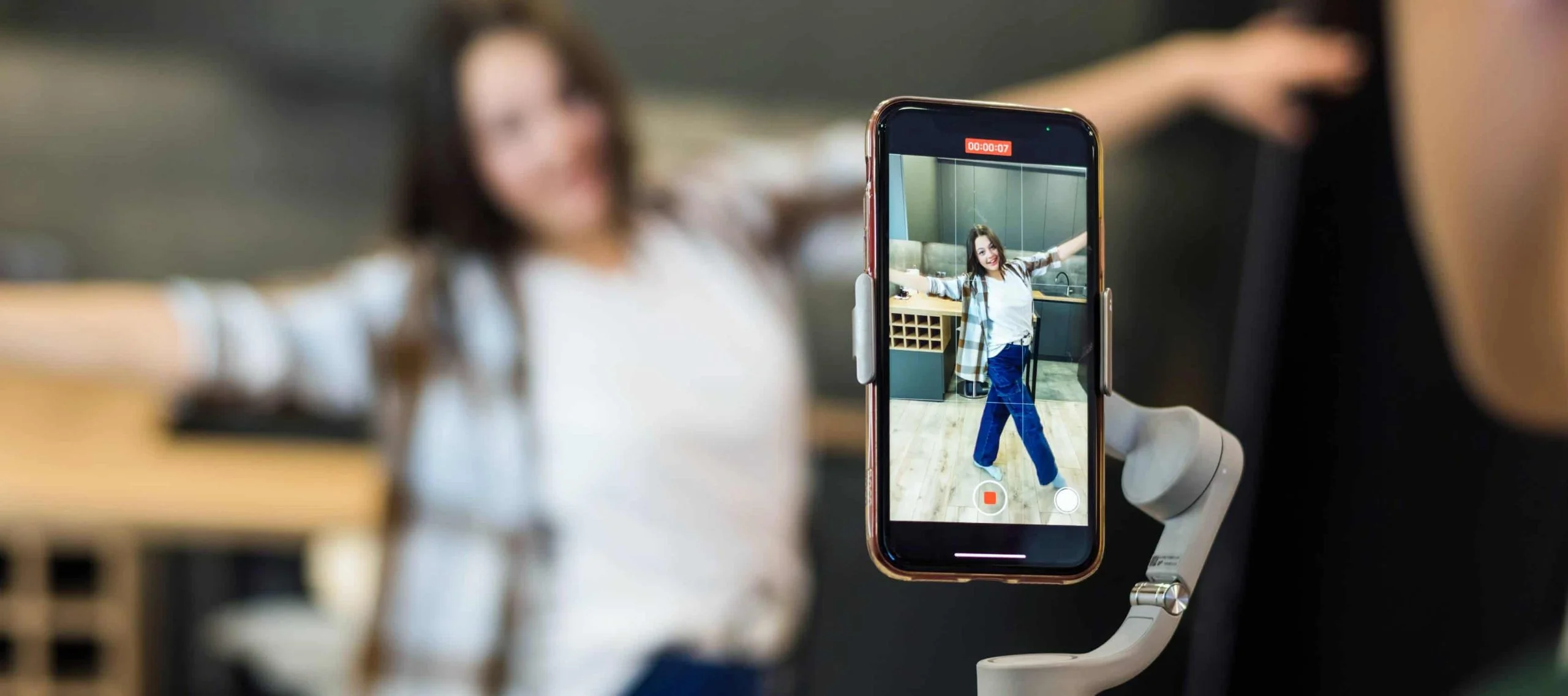 Creadora de contenido grabando un video con un móvil bajo las condiciones de la nueva Ley de Influencers.